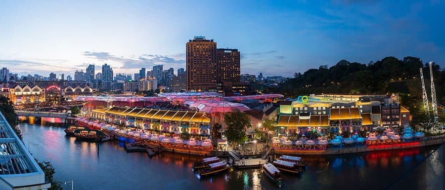 Clarke Quay, Singapore — River boats and the city lit up.